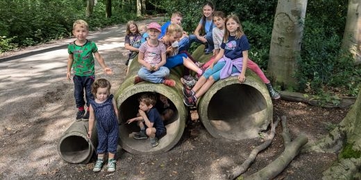 Kinder im Wald auf Röhren aus Beton